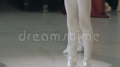 芭蕾。 在芭蕾训练中，一个穿白色芭蕾舞鞋的女孩`了她的腿。 <strong>古典</strong>舞蹈<strong>元素</strong>...